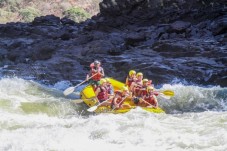 A group of people white water rafting